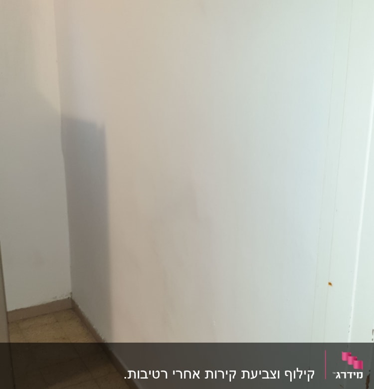 קיר צבוע בלבן עם רצפת אריחים